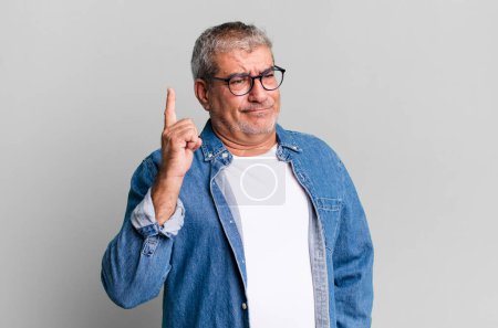 Photo for Middle age senior man feeling like a genius holding finger proudly up in the air after realizing a great idea, saying eureka - Royalty Free Image