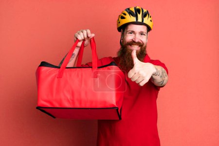 Téléchargez les photos : Barbe longue homme se sentant fier, souriant positivement avec les pouces levés. concept de livraison de pizza - en image libre de droit