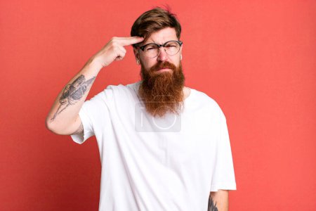 Photo for Long beard and red hair man feeling confused and puzzled, showing you are insane - Royalty Free Image