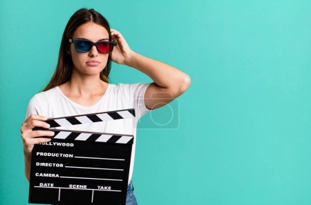 Photo for Young pretty woman smiling happily and daydreaming or doubting. cinema film or movie concept - Royalty Free Image