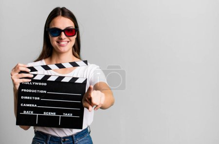 Téléchargez les photos : Jeune jolie femme pointant vers la caméra vous choisissant. film cinéma ou concept de film - en image libre de droit