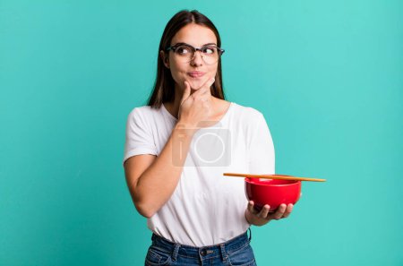 Photo for Young pretty woman smiling with a happy, confident expression with hand on chin. japanese ramen noodles concept - Royalty Free Image