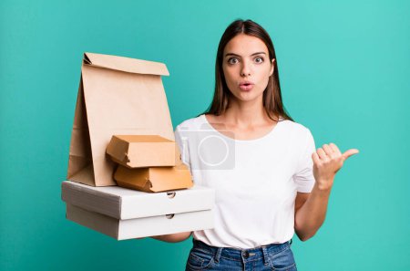 Photo for Young pretty woman looking astonished in disbelief. delivery and take away concept - Royalty Free Image