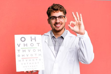 Photo for Young adult caucasian man feeling happy, showing approval with okay gesture. optical vision test concept - Royalty Free Image