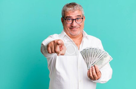 Photo for Middle age senior man pointing at camera choosing you. dollar banknotes concept - Royalty Free Image