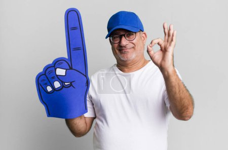 Foto de Hombre mayor de mediana edad sintiéndose feliz, mostrando aprobación con buen gesto. concepto de ventilador número uno - Imagen libre de derechos