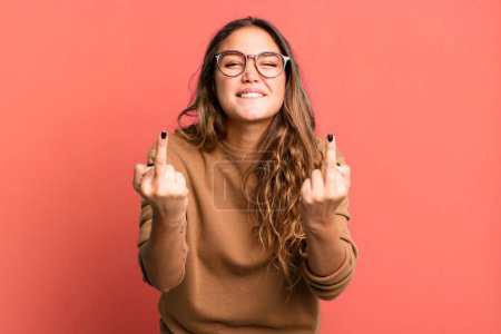 Photo for Young pretty woman feeling provocative, aggressive and obscene, flipping the middle finger, with a rebellious attitude - Royalty Free Image