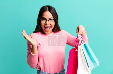 Photo for Hispanic pretty woman feeling happy and astonished at something unbelievable. shopping concept - Royalty Free Image
