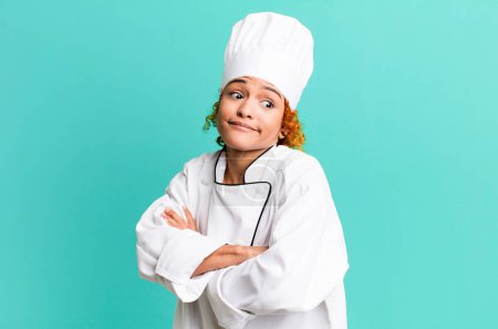 Photo for Red hair pretty woman shrugging, feeling confused and uncertain. chef concept - Royalty Free Image