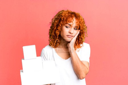 Photo for Red hair pretty woman feeling bored, frustrated and sleepy after a tiresome. blank packages boxes concept - Royalty Free Image