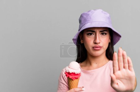 Foto de Mirando seriamente mostrando la palma abierta haciendo gesto de parada. helados y concepto de verano - Imagen libre de derechos