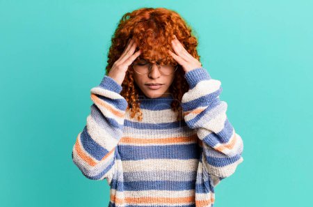 Photo for Redhair pretty woman looking stressed and frustrated, working under pressure with a headache and troubled with problems - Royalty Free Image