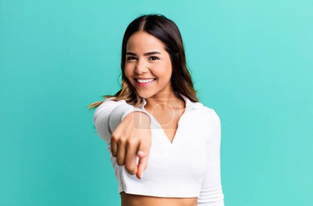 Photo for Hispanic pretty woman pointing at camera with a satisfied, confident, friendly smile, choosing you - Royalty Free Image