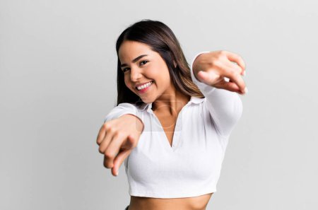 Téléchargez les photos : Hispanique jolie femme se sentant heureuse et confiante, pointant vers la caméra avec les deux mains et riant, vous choisissant - en image libre de droit