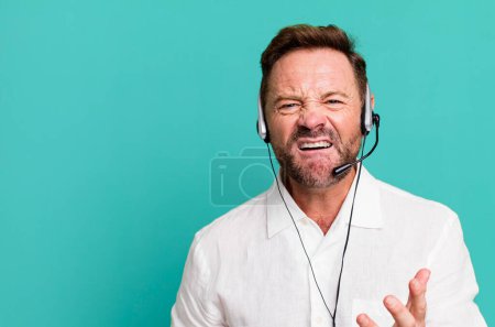 Foto de Hombre de mediana edad que parece enojado, molesto y frustrado. concepto de telemarketer - Imagen libre de derechos