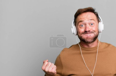 Photo for Middle age man listening music with his headphones sport coach concept with a soccer ball - Royalty Free Image