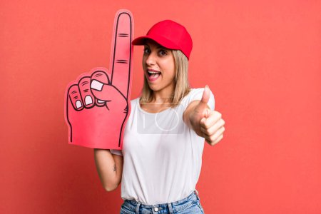 Photo for Pretty blonde woman feeling proud,smiling positively with thumbs up. number one fan concept - Royalty Free Image