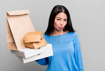 Foto de Mujer bonita hispana sintiéndose triste y llorona con una mirada infeliz y llorando. con paquetes de comida rápida para llevar - Imagen libre de derechos