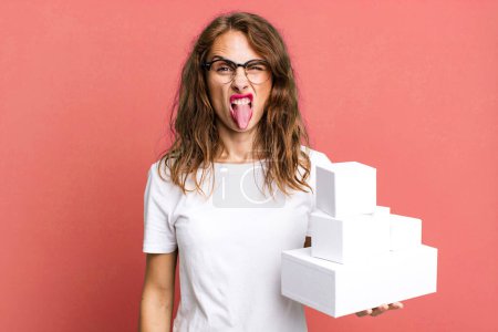 Photo for Hispanic pretty woman feeling disgusted and irritated and tongue out. with white boxes packages - Royalty Free Image
