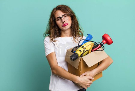 Photo for Hispanic pretty woman feeling sad and whiney with an unhappy look and crying with a tool box. handyman concept - Royalty Free Image