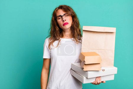 Photo for Hispanic pretty woman feeling sad and whiney with an unhappy look and crying. take away fast food packages concept - Royalty Free Image