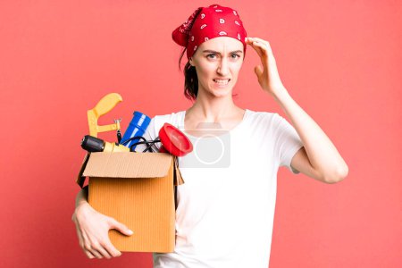 Photo for Young pretty woman feeling confused and puzzled, showing you are insane. housekeeper and toolbox concept - Royalty Free Image