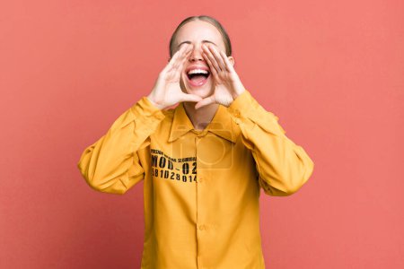Foto de Mujer guapa caucásica sentirse feliz, dando un gran grito con las manos al lado de la boca. concepto de culpa - Imagen libre de derechos