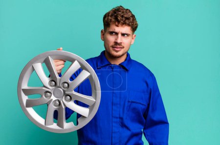 Photo for Young adult caucasian man feeling sad, upset or angry and looking to the side. car repairman or mechanic concept - Royalty Free Image
