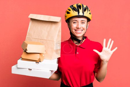 Photo for Smiling and looking friendly, showing number five. fast food delivery or take away - Royalty Free Image