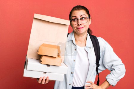 Photo for Pretty hispanic woman shrugging, feeling confused and uncertain. delivery fast food take away concept - Royalty Free Image