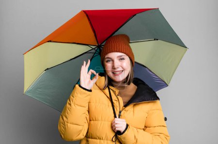 Téléchargez les photos : Young pretty woman wearing an anorak and a umbrella - en image libre de droit