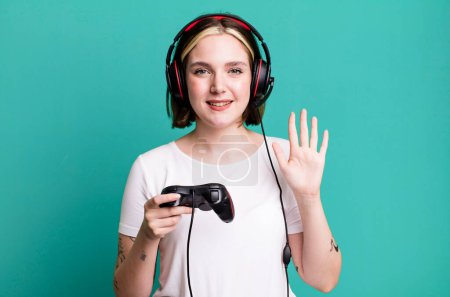 Foto de Joven bonita mujer sonriendo y buscando amigable, mostrando el número cinco. concepto de jugador - Imagen libre de derechos