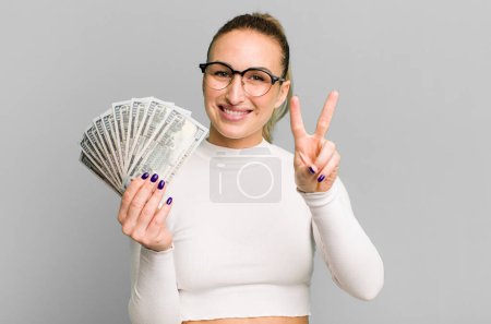 Téléchargez les photos : Jeune jolie femme avec des billets en dollars - en image libre de droit