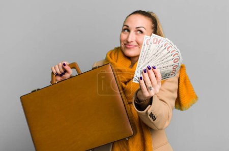 Foto de Young pretty woman with a leather case and dollar banknotes - Imagen libre de derechos