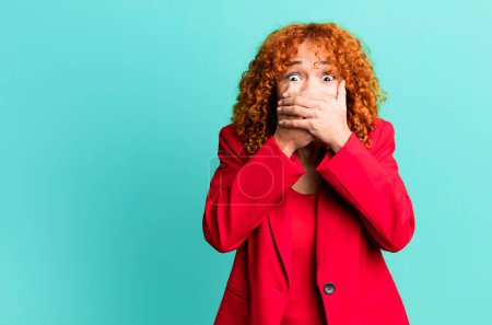 Photo for Red hair pretty woman covering mouth with hands with a shocked. businesswoman concept - Royalty Free Image