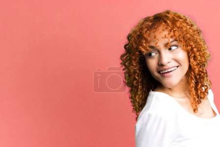 Photo for Red hair pretty woman with a copy space to the side. presenting something - Royalty Free Image