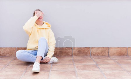Photo for Pretty caucasian sitting  woman covering eyes with one hand feeling scared or anxious, wondering or blindly waiting for a surprise - Royalty Free Image