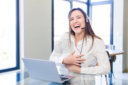 Téléchargez les photos : Jeune jolie femme riant à haute voix à une blague hilarante. concept de télévendeur - en image libre de droit