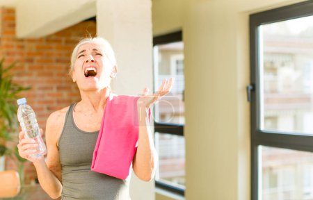 Photo for Senior pretty woman screaming with hands up in the air. fitness concept - Royalty Free Image
