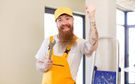 Téléchargez les photos : Homme aux cheveux roux se sentant comme un génie heureux et excité après avoir réalisé une idée réparer la maison. concept bricoleur - en image libre de droit