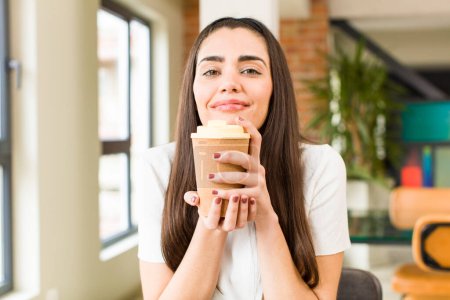 Téléchargez les photos : Jolie jeune femme avec un café chaud à la maison. design intérieur de la maison - en image libre de droit