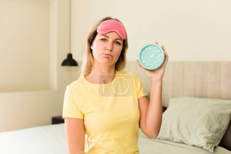 Photo for Pretty young woman with an alarm clock. house interior design - Royalty Free Image