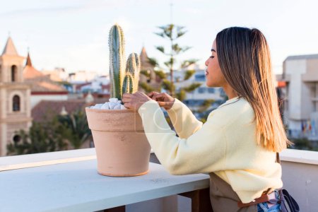 Téléchargez les photos : Pretty latin woman gardering with a plant - en image libre de droit