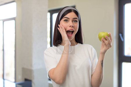 Téléchargez les photos : Jolie jeune femme se sentant heureuse et étonnée de quelque chose d'incroyable. concept de pomme - en image libre de droit