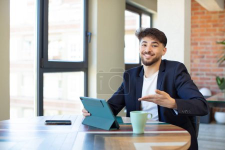 Photo for Young handsome man smiling cheerfully, feeling happy and showing a concept. touch screen pad concept - Royalty Free Image