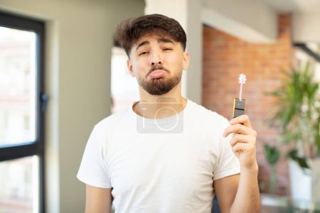Photo for Young handsome man feeling sad and whiney with an unhappy look and crying. new home key concept - Royalty Free Image