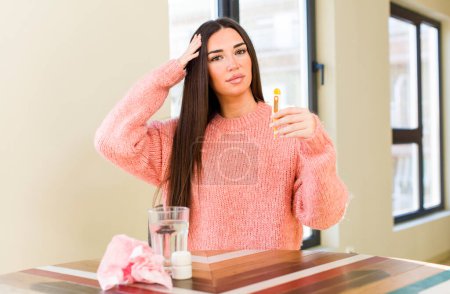 Téléchargez les photos : Jeune jolie femme avec un verre d'eau et des pilules. concept de grippe - en image libre de droit