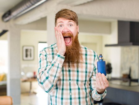Photo for Red hair man feeling happy and astonished at something unbelievable with a vaper - Royalty Free Image