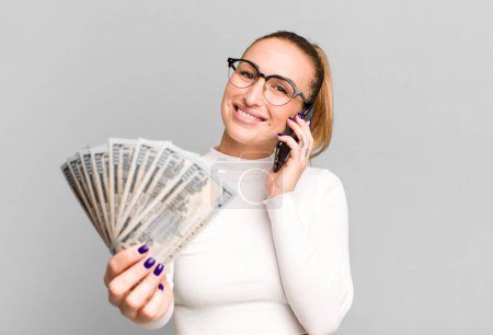 Photo for Young pretty woman with dollar banknotes and a smartphone - Royalty Free Image