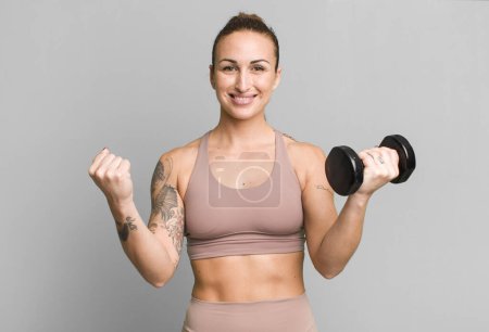 Photo for Young pretty woman with dumbbell - Royalty Free Image